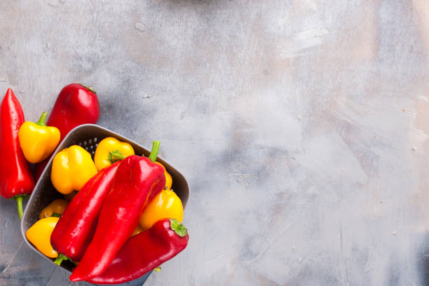 istock Sweet pepper is yellow and red, on a gray background. Free space for text, frame. Top view 1027364676
