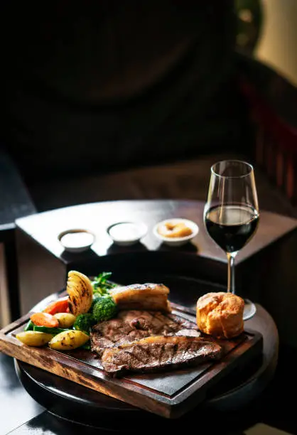 Photo of gourmet sunday roast beef traditional british meal set on old wooden pub table