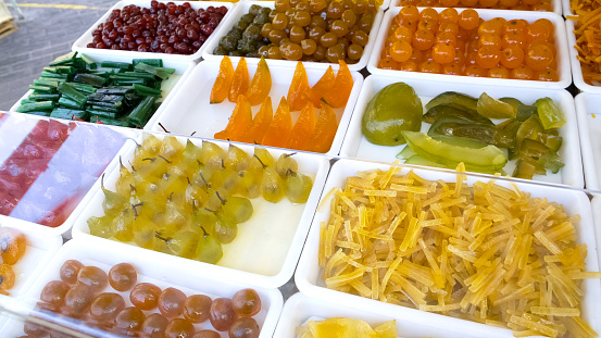 Candied fruit presented on showcase beckoning customers, appetizing sweets