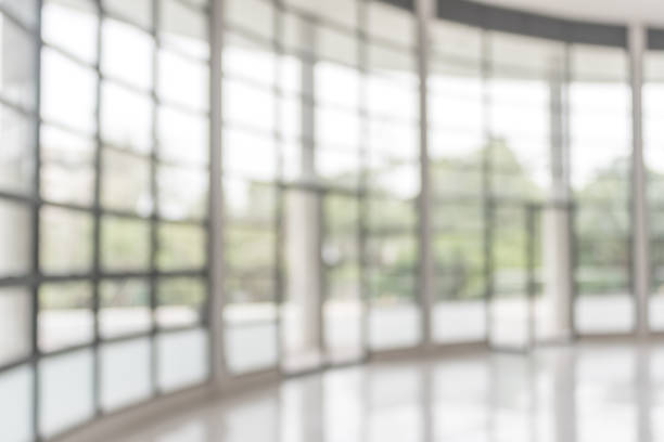 istock Blur background interior view looking out toward to empty office lobby and entrance doors and glass curtain wall 1027407070