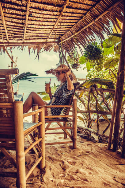 Woman drinks fresh juice on the beach