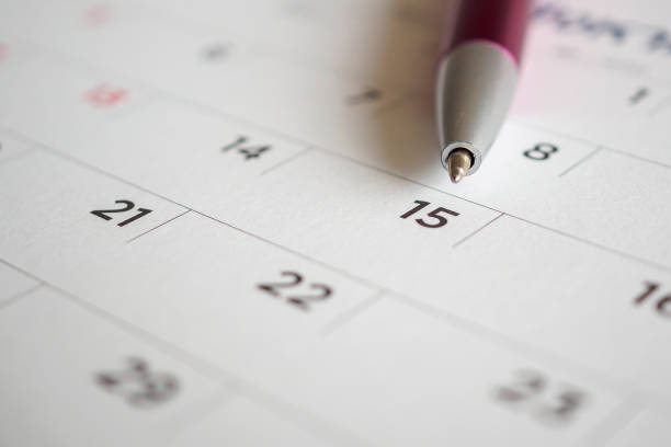 istock Calendar page with pen point at 15th date 1027407220