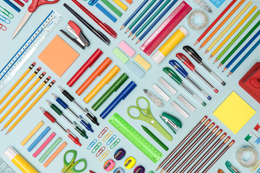 Neatly arranged stationery items on a blue background