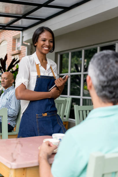 istock Waitress laughing and taking an order from a customer 1027410290