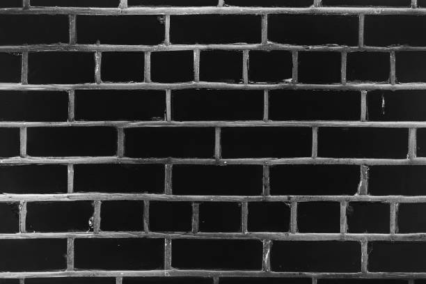 Old realistic brick wall made of black brick in different shads. Burnt smooth brickwork in grayscale. Monochrome background.