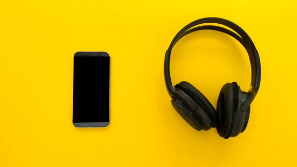 istock Headphones with smartphone over yellow background 1027418562