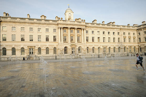 garçon courir à travers la fontaine de l'hôtel courtyard de somerset house, londres - somerset house photos et images de collection