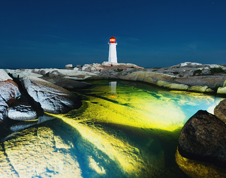 Peggy's Cove Lighthouse reflected in a deep tidal pool.  Long exposure with submersible lighting.