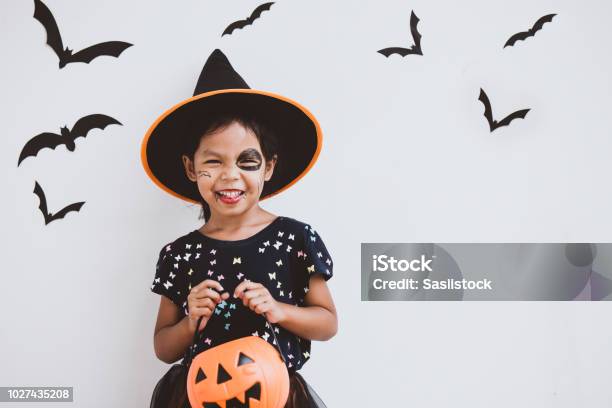 Happy Asian Little Child Girl In Costumes And Makeup Having Fun On Halloween Celebration Stock Photo - Download Image Now