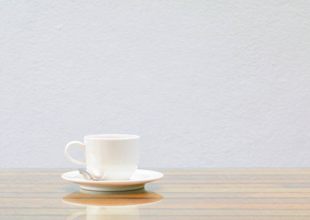 istock coffee cup white On the glass table wooden and a cement wall background. copy space 1027463790