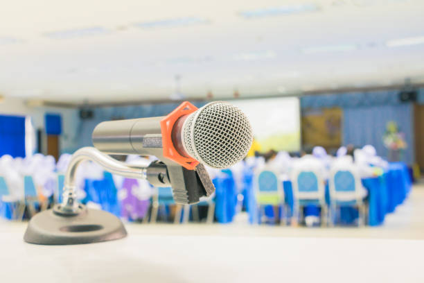 istock Close up microphone wireless Stand on white table in business conference interior seminar meeting room and Background blur 1027463800