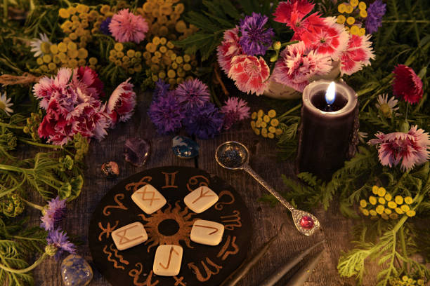 istock Still life with old runes, zodiac circle, black candle, flowers and ritual objects 1027466778