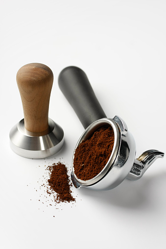 Coffee grinder and coffee beans put on old wooden with white background.