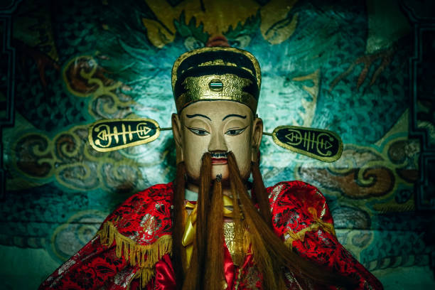 dio cinese con barba lunga in condizioni di scarsa illuminazione - chinese god foto e immagini stock