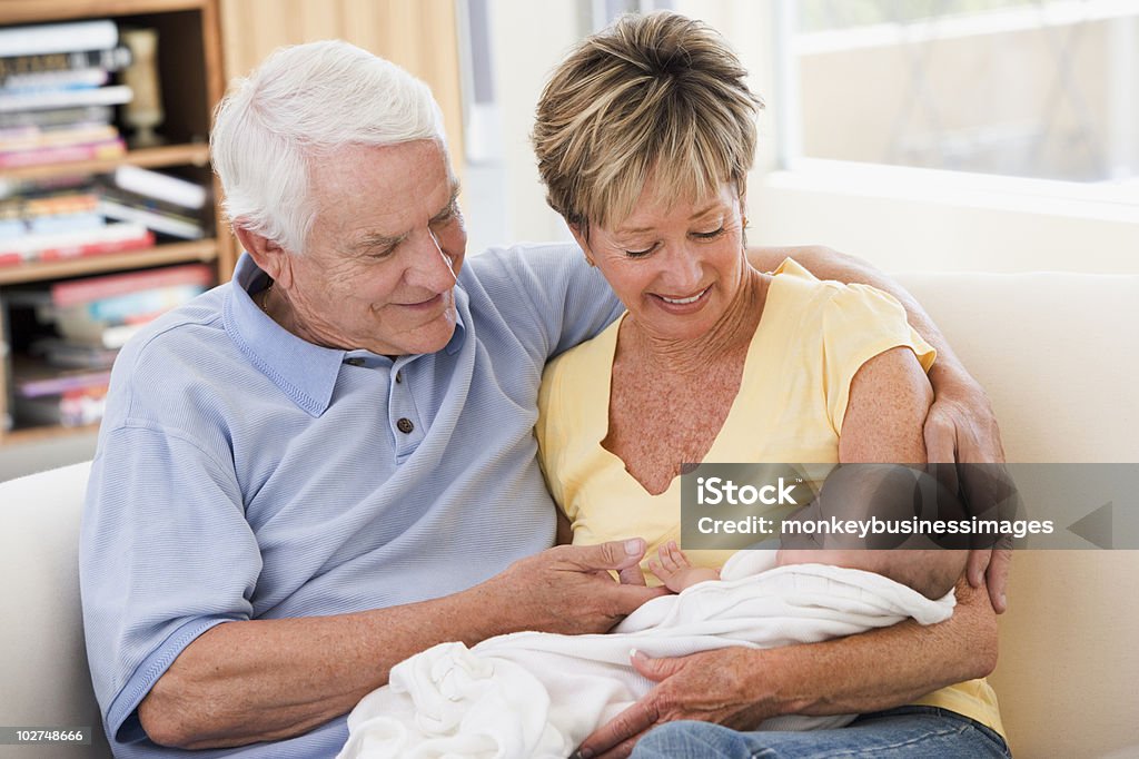 Abuelos en la sala de estar con el bebé - Foto de stock de Abuelo libre de derechos