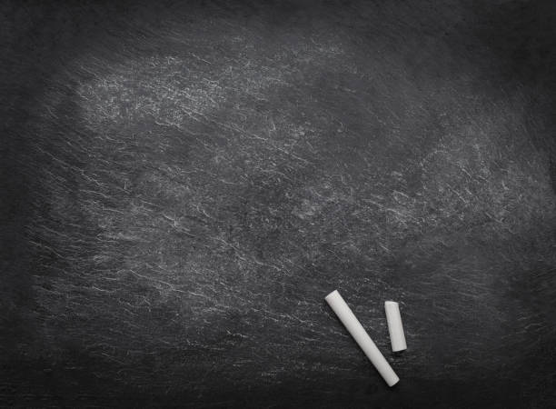 istock Black empty chalk board with two pieces of chalk. Copyspace. Back to school concept. 1027490996