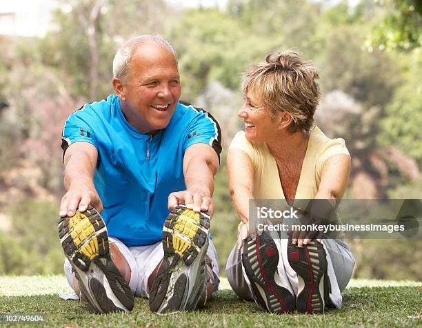 Senior Couple Exercising Together In Park Stock Photo - Download Image Now - 50-59 Years, 60-69 Years, Active Lifestyle