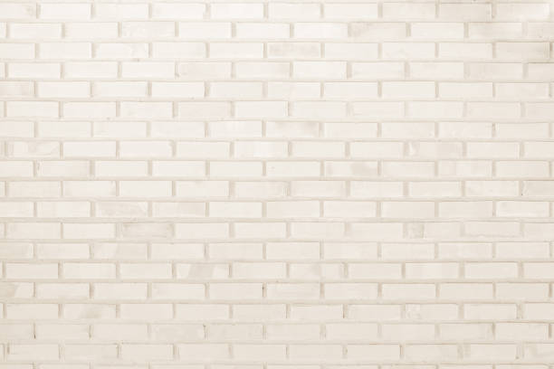istock Cream and white brick wall texture background. Brickwork or stonework flooring interior rock old pattern clean concrete grid uneven bricks design stack. 1027510542