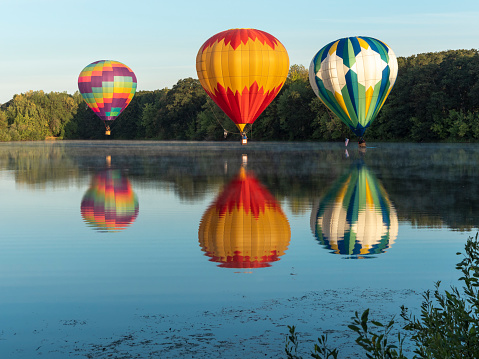 Albany, Oregon, USA - August 25, 2018: Hot-Air Balloons up in the air for the Northwest Art and Air Festival. They are over Freeway Lakes, a free Linn County public recreation area. The balloons are in flight with people in the wicker baskets. This free annual three-day Festival is held at Timber Linn Park, a city of Albany Oregon public park. It makes a great area for the Art sales booths, Music, food, Hot Air Balloon Launch area and more. The balloons Launch in the early mornings on Friday, Saturday and Sunday. This Saturday the balloons were floating to the South of Albany, near Freeway Lakes. The photo was taken from a public area.