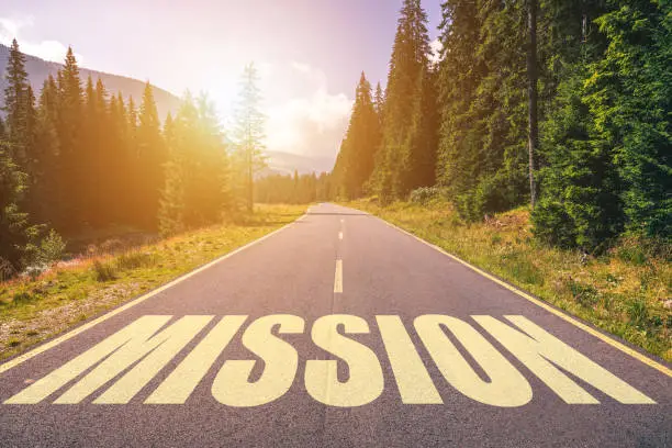 Photo of Mission word written on road in the mountains