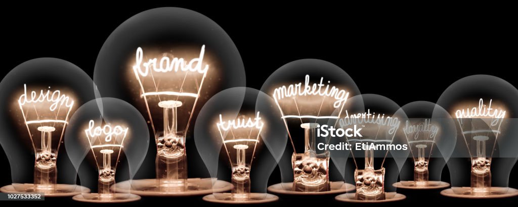 Light Bulbs Concept Photo of light bulbs with shining fibres in shape of BRAND concept related words isolated on black background Marketing Stock Photo