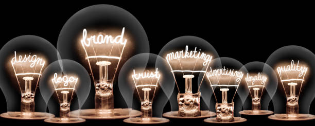 Light Bulbs Concept Photo of light bulbs with shining fibres in shape of BRAND concept related words isolated on black background branding identity business merchandise stock pictures, royalty-free photos & images