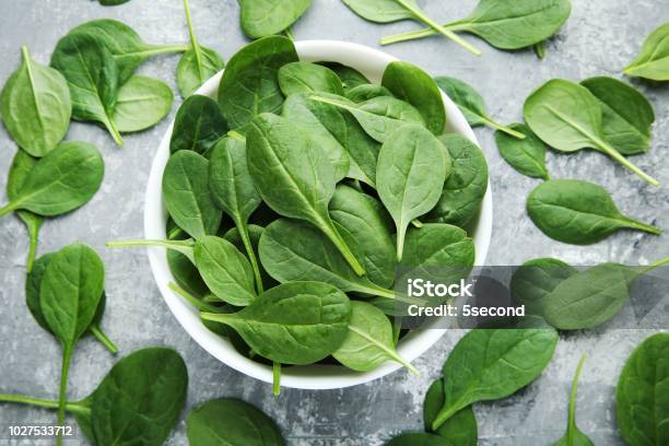 Spinach Leafs In Bowl On Grey Wooden Table Stock Photo - Download Image Now - Spinach, Bowl, Leaf