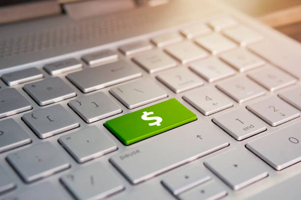 istock Closeup of computer keyboard with dollar button, Color button on the gray silver keyboard of modern ultrabook. caption on the button 1027539574