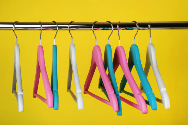 istock Colorful clothes hangers on yellow background 1027539618