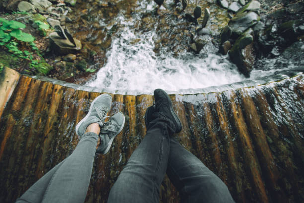 istock legs of two persons with waterfall on background 1027543372