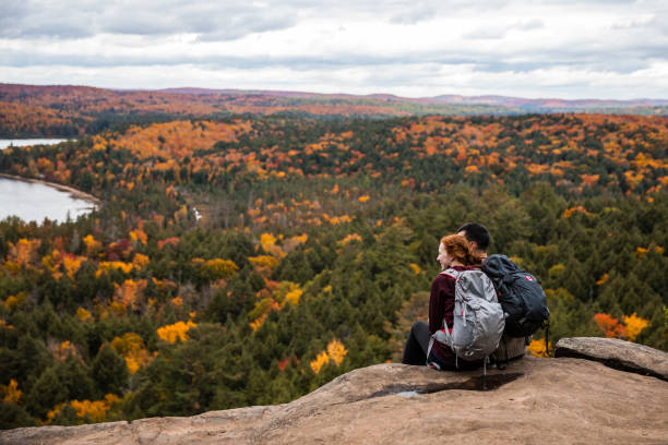 istock Young couple hiking in mountain and relaxing looking at view 1027543432