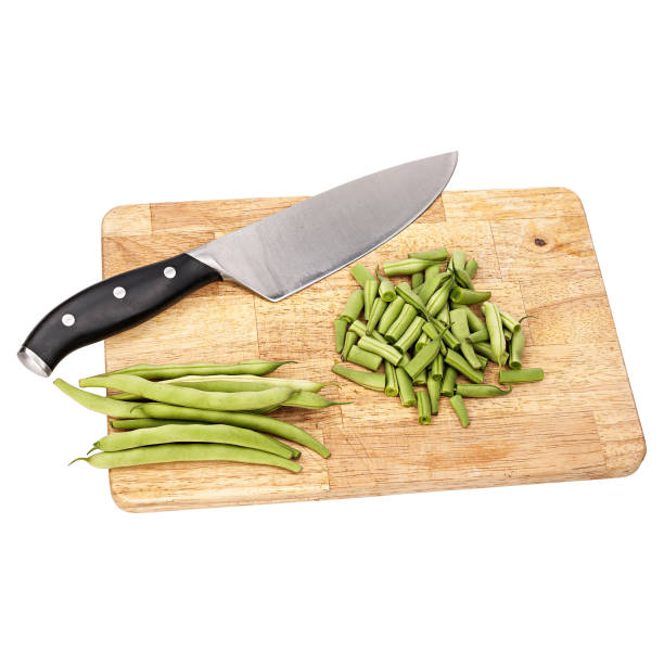 Fresh green beans on a cutting board on a table, white isolated background