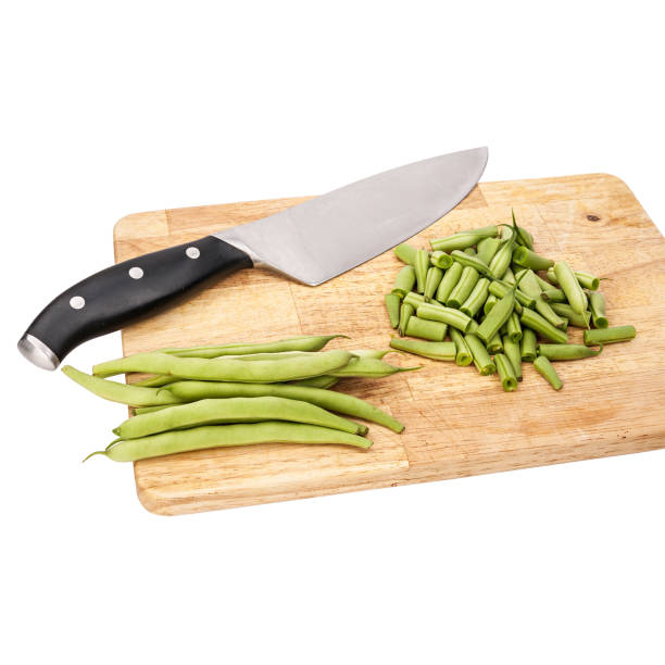 Fresh green beans on a cutting board on a table, white isolated background