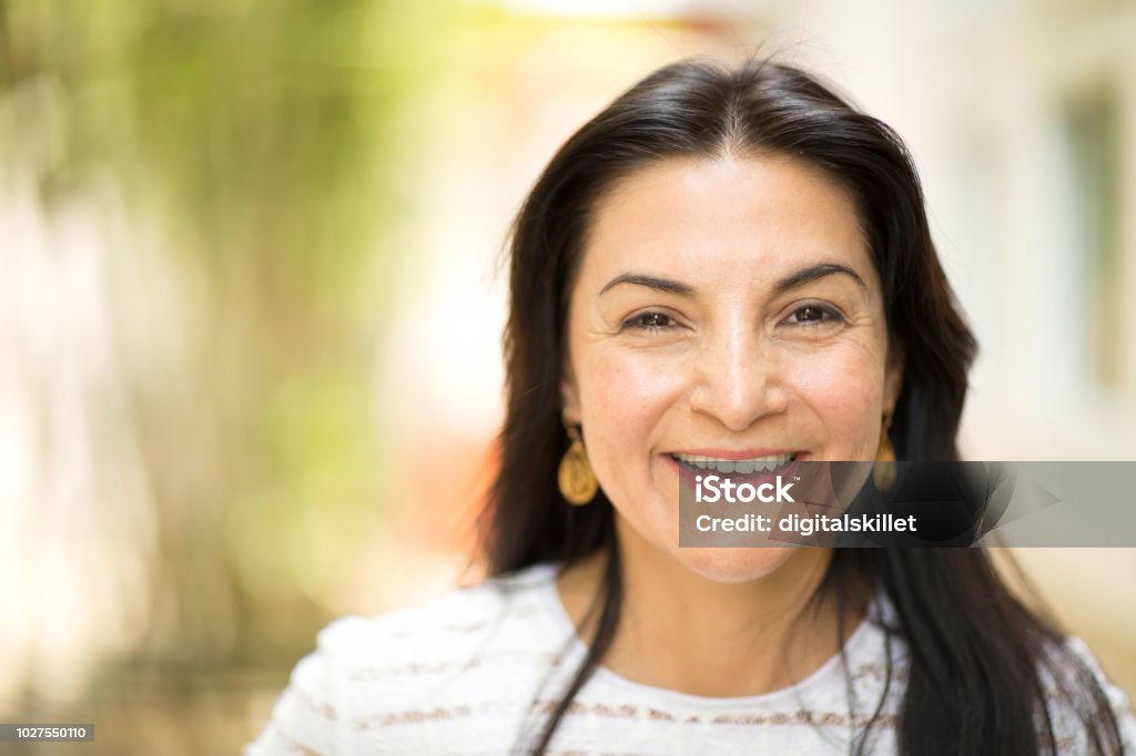 Mujer de Hispanic feliz sonriendo y de pie fuera. - Foto de stock de Mujeres libre de derechos