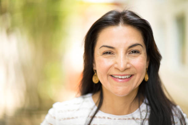 istock Happy Hispnaic woman smiling and standing outside. 1027550110