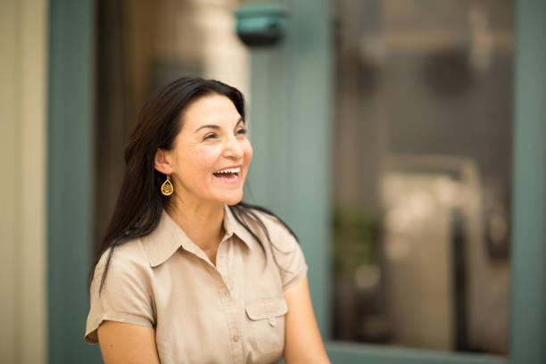 istock Happy Hispnaic woman smiling and standing outside. 1027554614