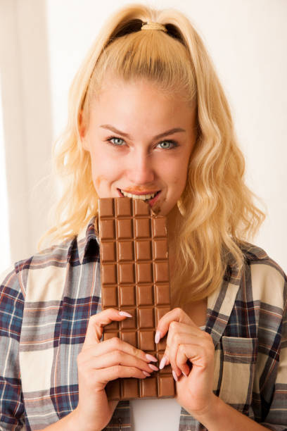 istock Beautiful blonde woman eats a big chocolate 1027554752
