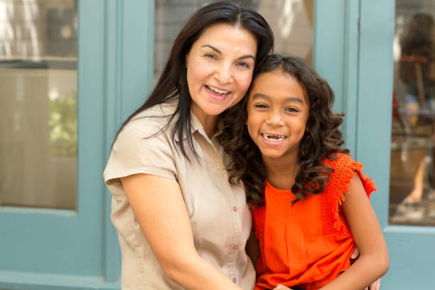 istock Happy Hispnaic mother smiling and hugging her daughter. 1027555136