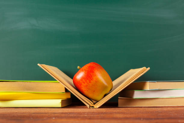istock back to school - apple and books with pencils and blackboard 1027555316