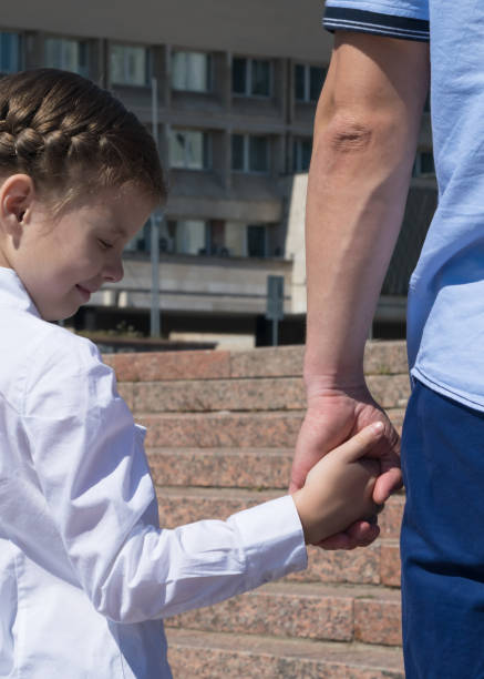 istock father leads his daughter's hand to school, close-up 1027563728