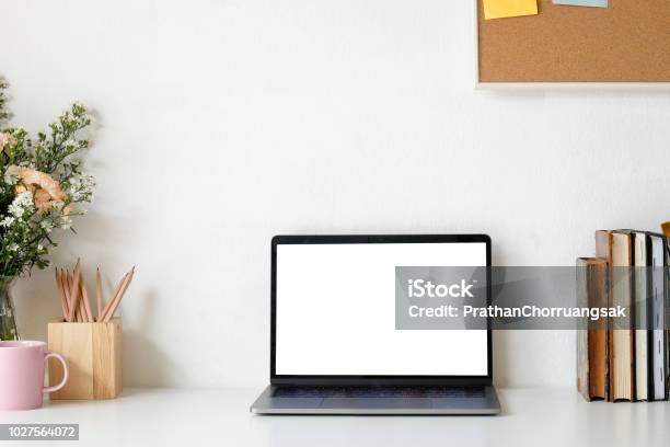Workspace Mock Up Laptop And Table Of Creative Desktop Of Female Designer With Nobody Flower Bouquet And Coffee Mug With Book Stock Photo - Download Image Now