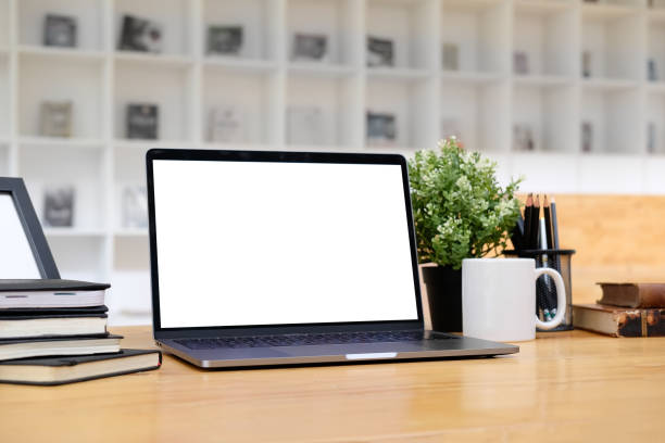 istock Mockup laptop computer on wooden table with library background. 1027567484