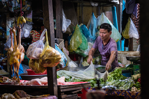 Phnom Penh, Camdodia - May 14, 2018: Young man working at the Russian Market of Phnom Penh.