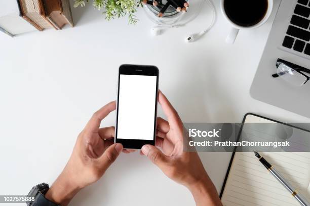 Top View Office Desk With Mockup Smartphone On Hands With Empty Display Screen Stock Photo - Download Image Now