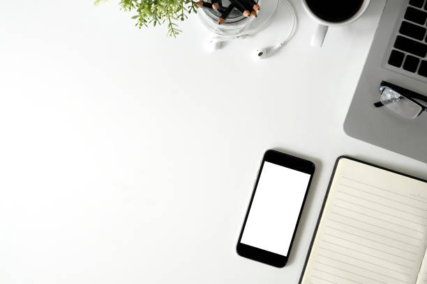 istock Mockup smartphone on office desk with laptop and notebook paper, Copy space mockup mobile phone with top view. 1027578992