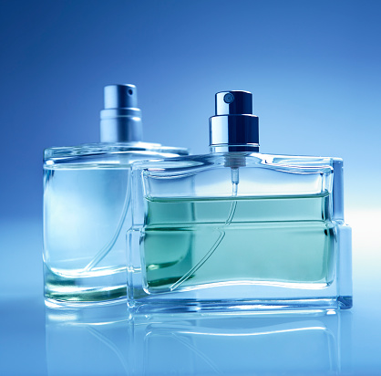 Shallow focus on two perfume bottles.Focus on foreground bottle.General cool blue tone.