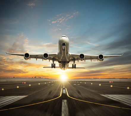 Huge two storeys commercial jetliner taking of runway. Modern and fastest mode of transportation. Dramatic sunset sky on background