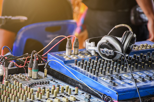 Sound mixer control panel with headphone in outdoor concert event.