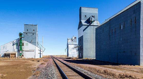 Grain storage by railway tracks in farming area of Montana.