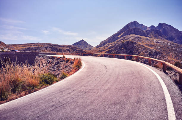 istock Vintage stylized picture of a mountain road bend. 1027599514